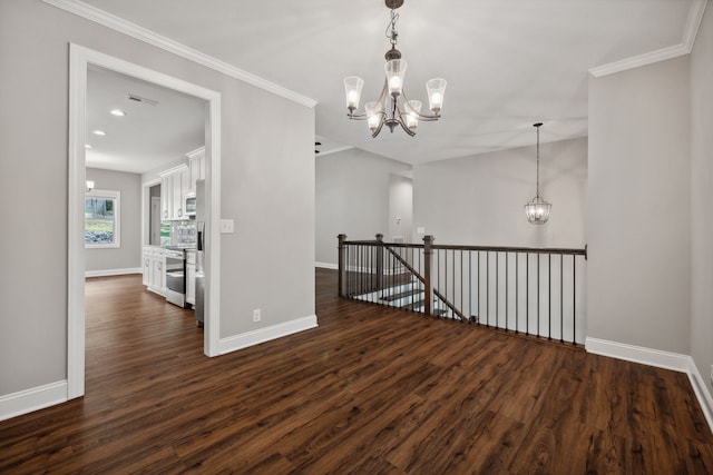 spare room with a notable chandelier, dark hardwood / wood-style flooring, and ornamental molding