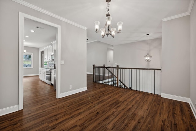 empty room featuring crown molding, dark hardwood / wood-style floors, and a chandelier