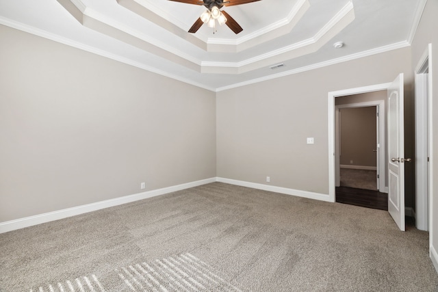 spare room featuring ceiling fan, crown molding, a raised ceiling, and light carpet