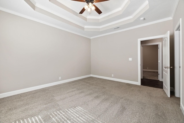 empty room featuring crown molding, ceiling fan, carpet flooring, and a raised ceiling