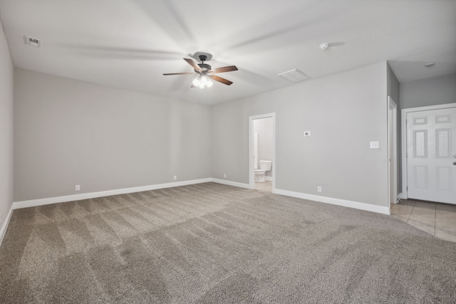 spare room with ceiling fan and light colored carpet