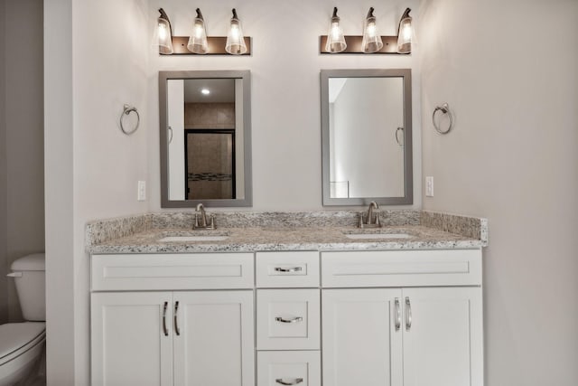 bathroom featuring vanity, walk in shower, and toilet