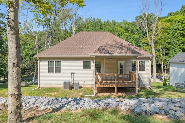 rear view of house featuring central AC, a deck, ceiling fan, and a lawn