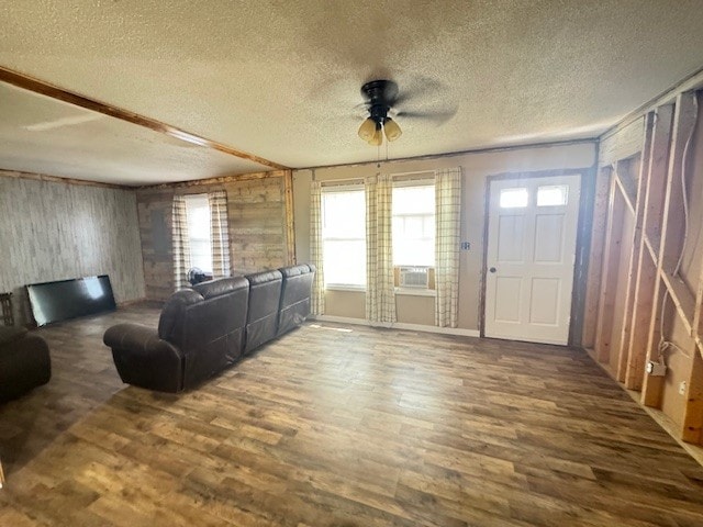 living room with ceiling fan, dark hardwood / wood-style floors, cooling unit, and a textured ceiling