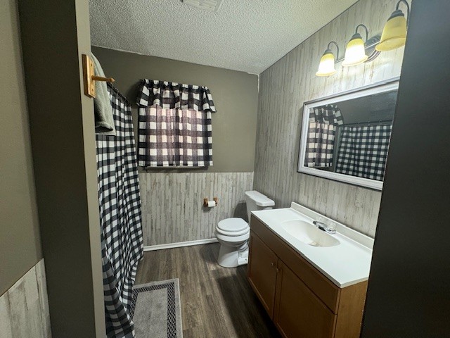 bathroom featuring vanity, toilet, a textured ceiling, and hardwood / wood-style flooring