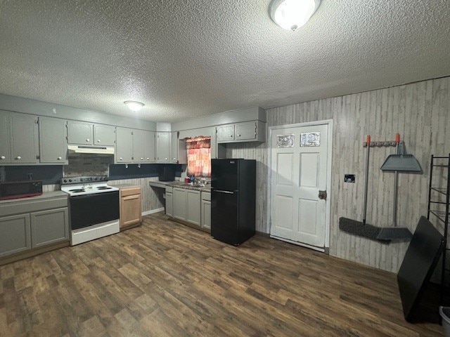 kitchen featuring a textured ceiling, black fridge, dark hardwood / wood-style flooring, and electric stove