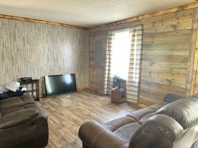 living room with wood walls, wood-type flooring, and a textured ceiling