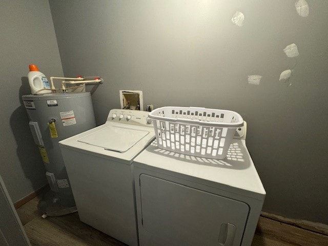 clothes washing area featuring electric water heater, dark hardwood / wood-style floors, and separate washer and dryer