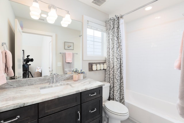 full bathroom featuring vanity, shower / bath combination with curtain, and toilet