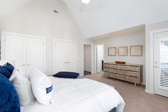 carpeted bedroom featuring two closets, high vaulted ceiling, and ceiling fan