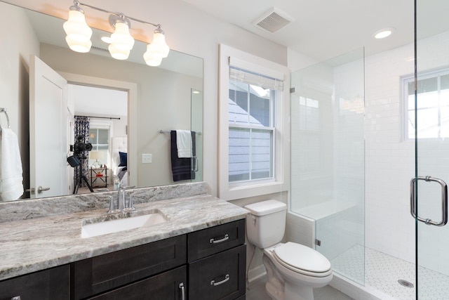 bathroom with vanity, an enclosed shower, and toilet