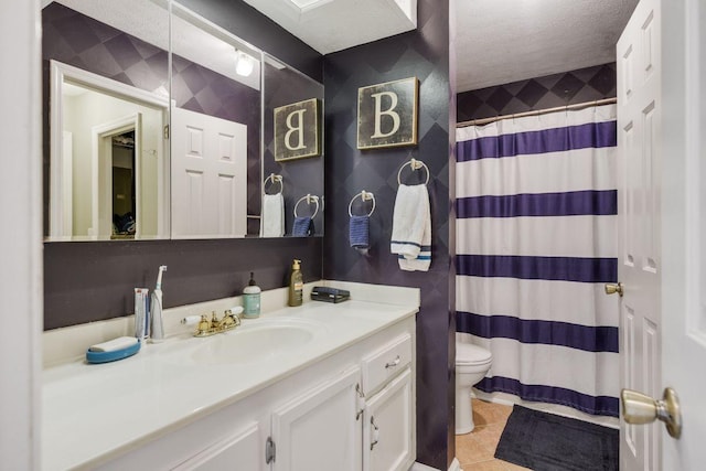 bathroom with vanity, tile patterned flooring, toilet, and a textured ceiling