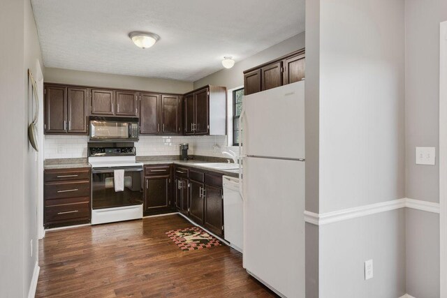 kitchen with white appliances, dark brown cabinetry, sink, and decorative backsplash