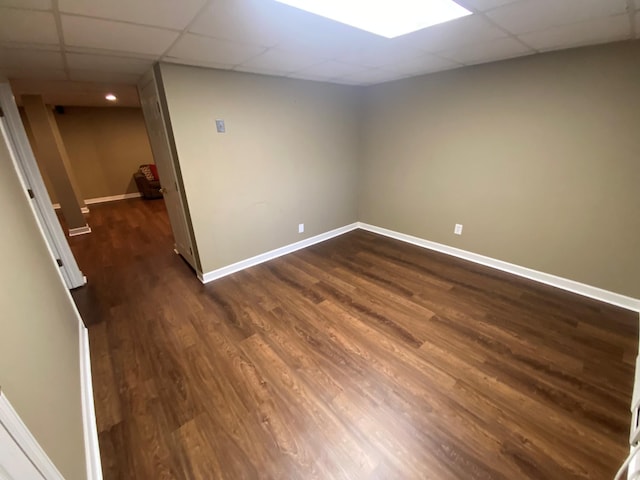 spare room with a drop ceiling and dark hardwood / wood-style floors