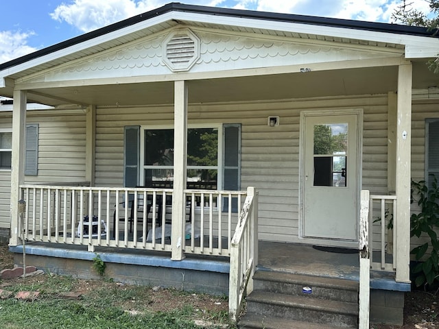 view of exterior entry featuring covered porch