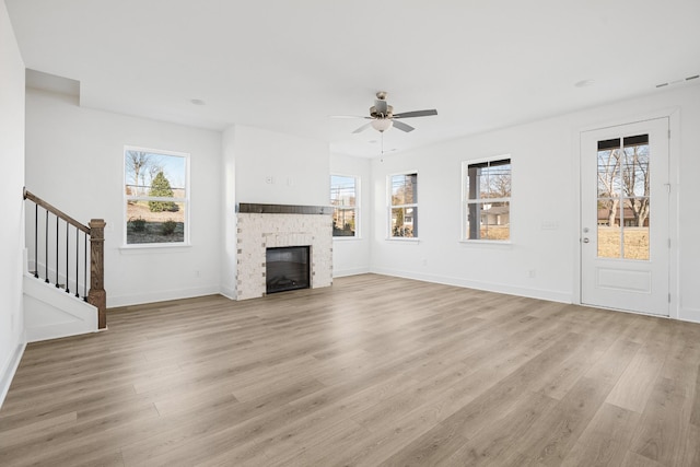 unfurnished living room featuring ceiling fan, light hardwood / wood-style floors, and a healthy amount of sunlight