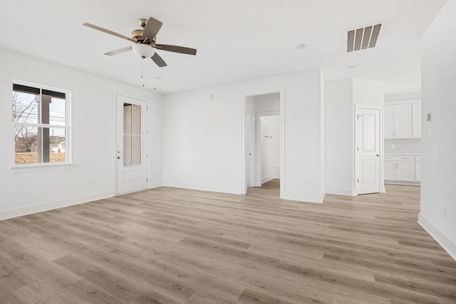 empty room with ceiling fan and light hardwood / wood-style floors