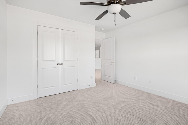 unfurnished bedroom with light colored carpet, a closet, and ceiling fan