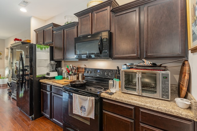 kitchen with wood-type flooring, black appliances, dark brown cabinets, and light stone countertops