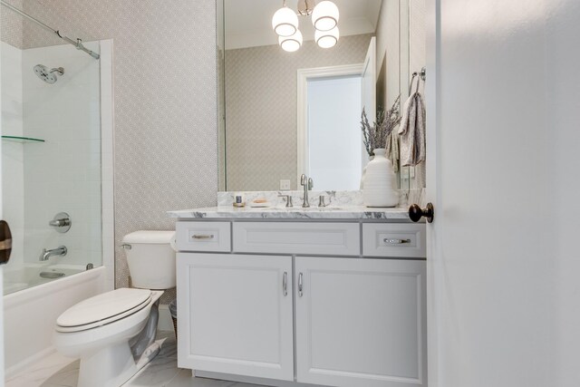 full bathroom featuring tiled shower / bath, vanity, toilet, and a notable chandelier