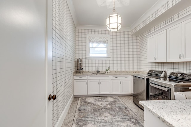 laundry room featuring cabinets, independent washer and dryer, ornamental molding, and sink