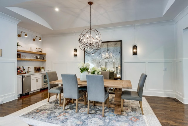 dining room with an inviting chandelier, dark hardwood / wood-style flooring, wet bar, and beverage cooler