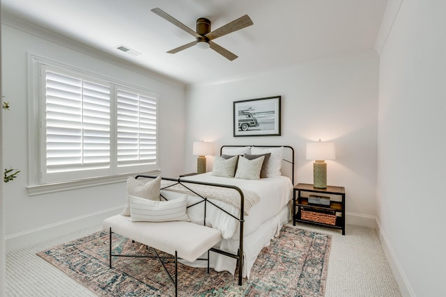 bedroom with crown molding, light colored carpet, and ceiling fan