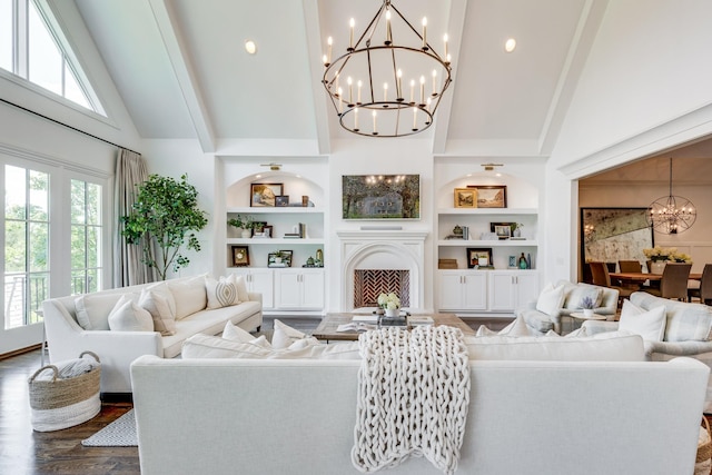 living room with a wealth of natural light, a notable chandelier, dark hardwood / wood-style flooring, and built in shelves