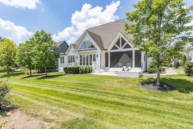 back of property with a patio, a sunroom, and a yard