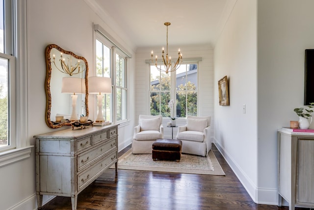 living area featuring an inviting chandelier, dark wood-type flooring, ornamental molding, and a healthy amount of sunlight