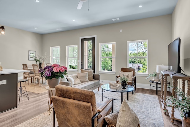 living room featuring light hardwood / wood-style floors and ceiling fan