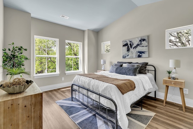 bedroom with lofted ceiling and wood-type flooring