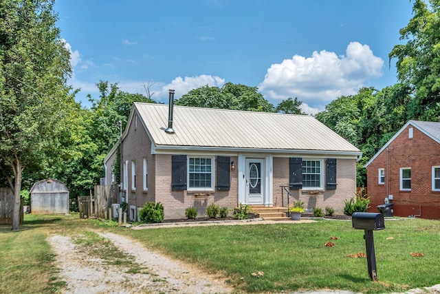 bungalow featuring a front yard and a storage shed