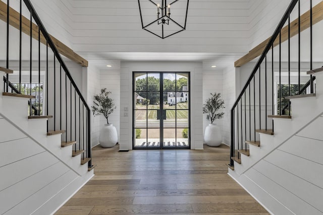 foyer with an inviting chandelier, wood-type flooring, and plenty of natural light