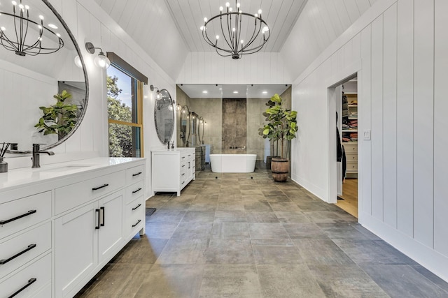 bathroom with a tub to relax in, lofted ceiling, vanity, and a chandelier