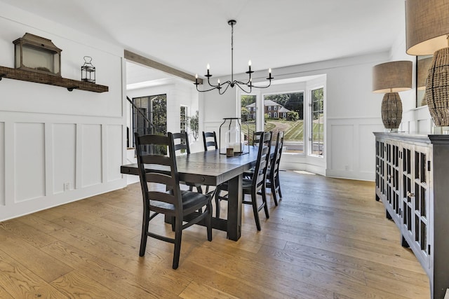 dining room with light hardwood / wood-style floors and a notable chandelier