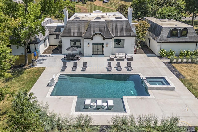 rear view of house with outdoor lounge area, a swimming pool with hot tub, an outdoor structure, and a patio area