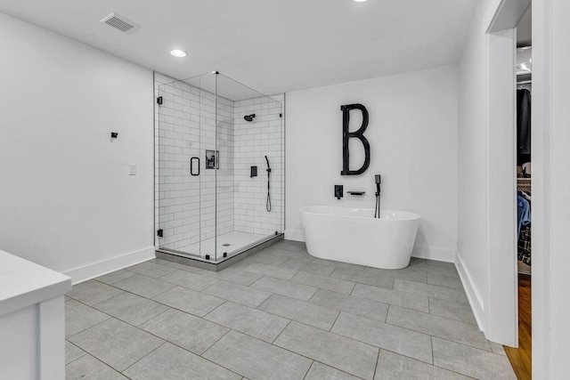 bathroom featuring tile patterned flooring and shower with separate bathtub