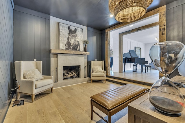 sitting room featuring light hardwood / wood-style floors and wood walls