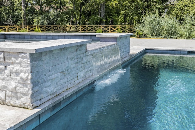 view of swimming pool with pool water feature