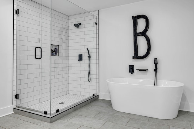 bathroom with shower with separate bathtub and tile patterned floors