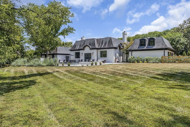 back of property featuring a yard and a patio area