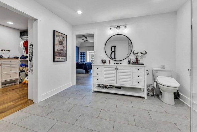 bathroom featuring hardwood / wood-style flooring, vanity, ceiling fan, and toilet