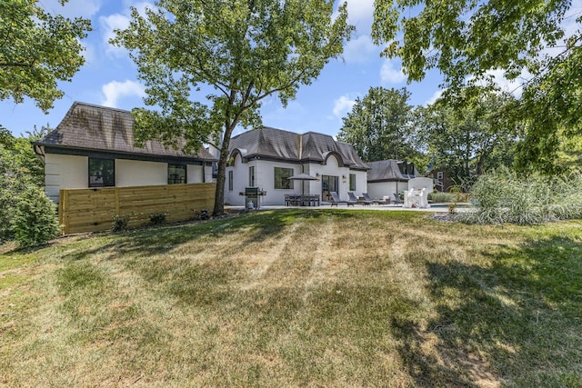 back of property featuring a yard and a patio area