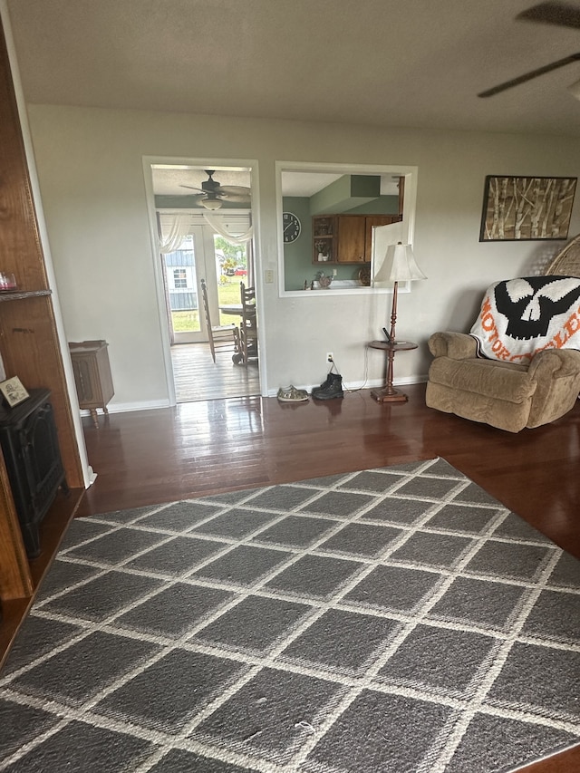 living room with dark wood-type flooring and ceiling fan