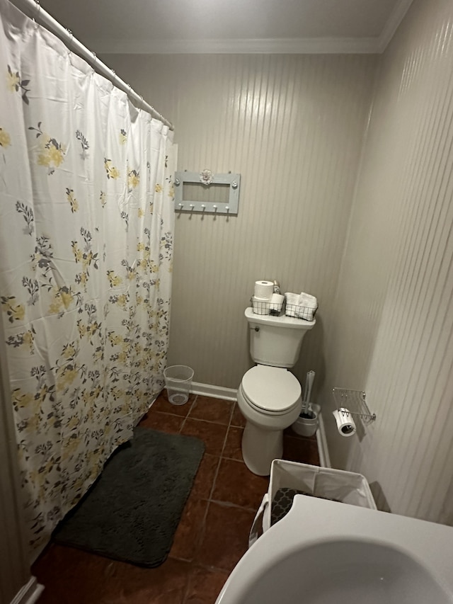 bathroom featuring crown molding, tile patterned flooring, and toilet