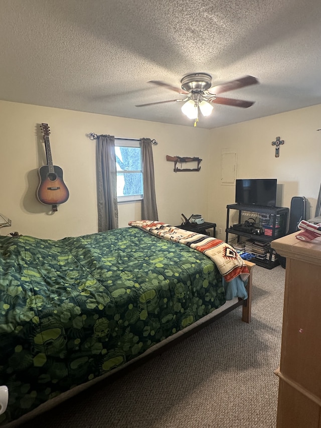 bedroom featuring ceiling fan, carpet floors, and a textured ceiling