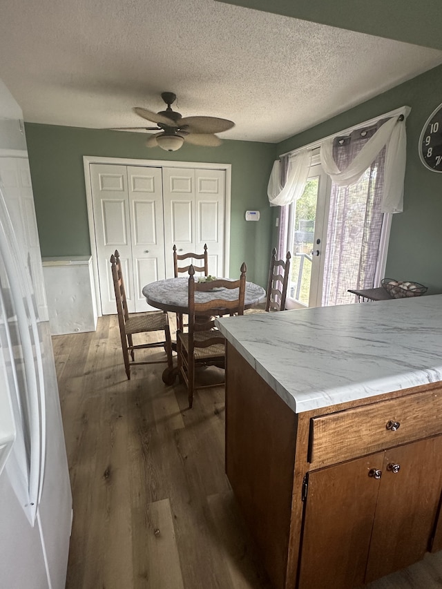 kitchen with dark hardwood / wood-style flooring, a textured ceiling, and ceiling fan