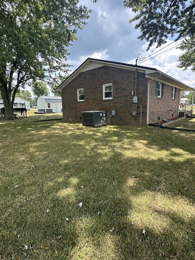 back of house featuring a lawn and cooling unit