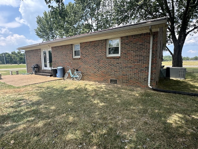 back of house featuring cooling unit and a lawn